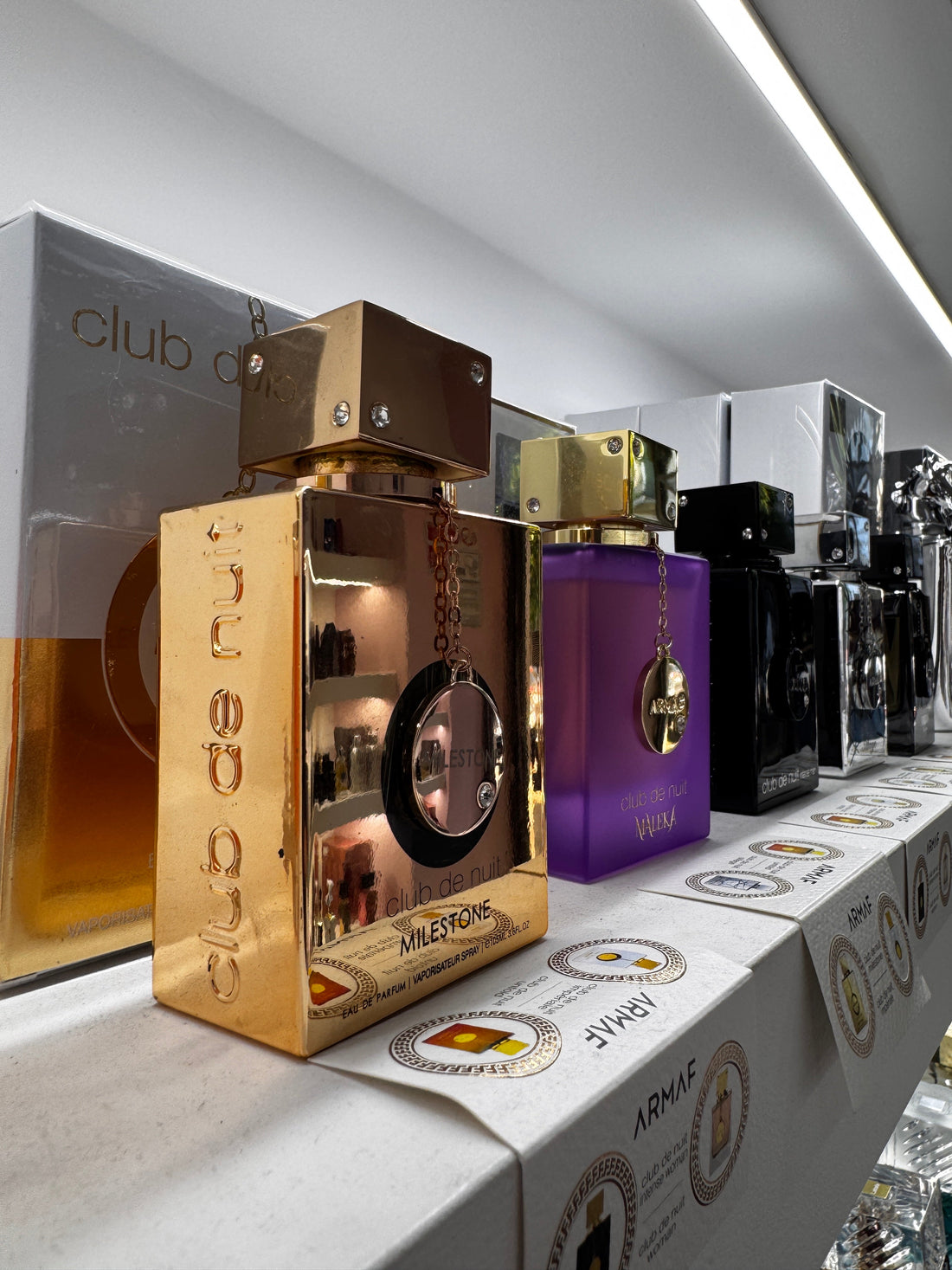 I profumi arabi più persistenti: flaconi Lattafa Khamrah, Asad Elixir e Afnan 9PM su scaffale della profumeria