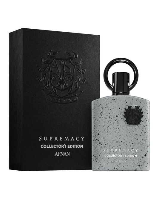 Flacone di profumo Afnan Supremacy Collector's Edition Eau de Parfum 100ml su base in pietra naturale con illuminazione soft-box e vegetazione sfocata.